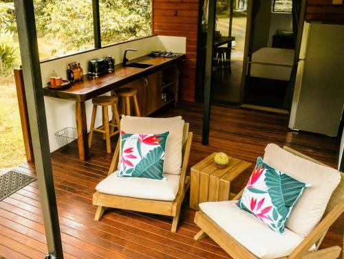 a porch with two chairs and a table and a counter at Cape Trib Farm in Cape Tribulation