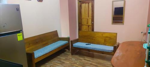 two wooden beds in a room with a door at AJjaa's Place in Sagada