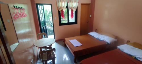 a small room with two beds and a table and a table at AJjaa's Place in Sagada