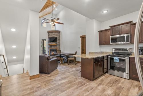 a kitchen with wooden cabinets and a dining room at 3BD Walk-In Near Silver Dollar City - Game Room - Pool - FREE TICKETS INCLUDED - RR-93B in Branson
