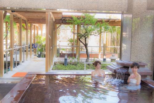 two women in a swimming pool in a building at Yuzawa Grand Hotel in Yuzawa