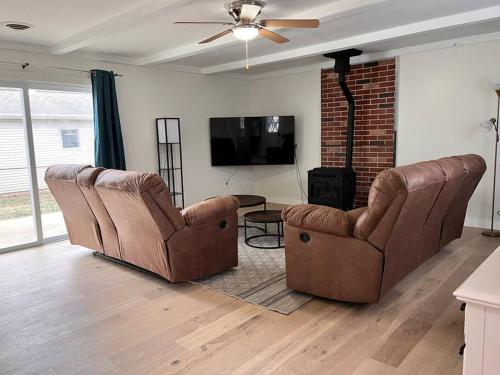 a living room with two chairs and a tv at House w Patio & Fenced Yard 10 minutes to Purdue in Lafayette