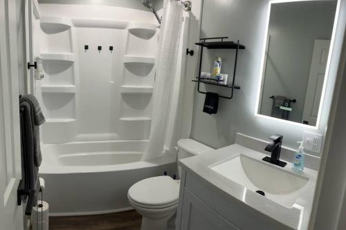 a white bathroom with a toilet and a sink at House w Patio & Fenced Yard 10 minutes to Purdue in Lafayette