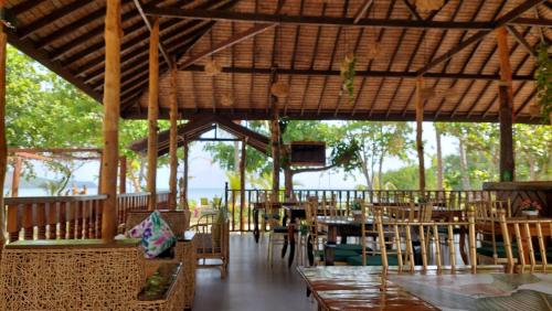 a pavilion with tables and chairs in a restaurant at La Tranquilidad Beach Club 