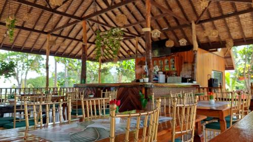 a restaurant with wooden tables and chairs and a bar at La Tranquilidad Twin Beach Resort in Dipnay