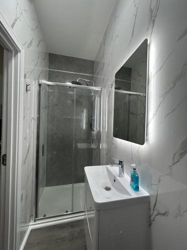 a bathroom with a shower and a sink and a mirror at studio in Ilford