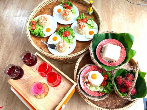 a table with plates of food and glasses of wine at Cana Garden House 1 โฮมสเตย์ in Ban Khok