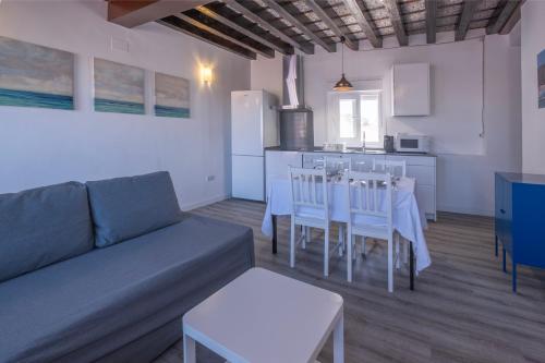 een woonkamer met een bank en een tafel en stoelen bij El mirador del Mentidero in Cádiz