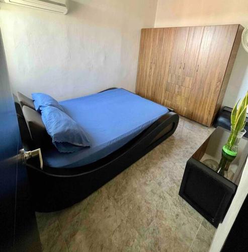 una camera da letto con un letto con una coperta blu e un tavolo di Acogedor apartamento en conjunto residencial a Soledad