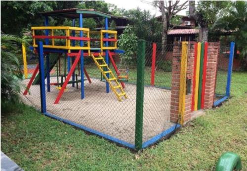 um parque infantil com um equipamento de brincar colorido num quintal em Casa Vitral - Em condomínio fechado - Aldeia/PE em Pau dʼAlho