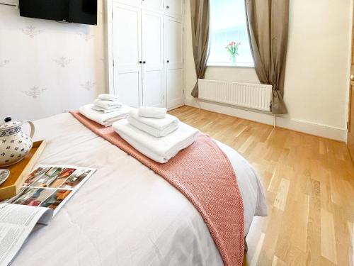 a bedroom with a bed with towels on it at Wisteria Cottage in Uppingham