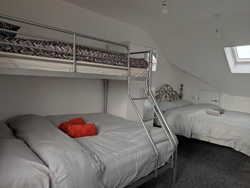a bedroom with two bunk beds with red pillows on them at Rahal Ilford in Ilford