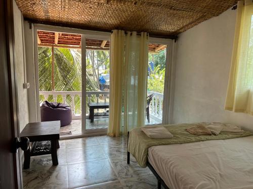 a bedroom with a bed and a large window at Palm Breeze Suites in Palolem