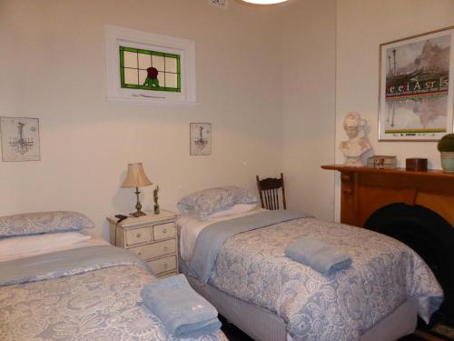 ein Schlafzimmer mit zwei Betten und einem Fenster in der Unterkunft Lakeside Bed & Breakfast in Perth