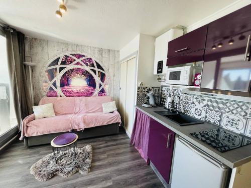 un salon avec un canapé rose dans une cuisine dans l'établissement Studio Cabine au Calme, Proche Port et Plage, Parking Gratuit - FR-1-723-96, au Cap d'Agde