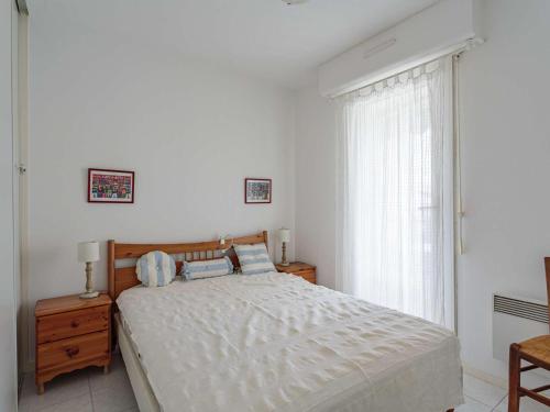 une chambre blanche avec un lit et une fenêtre dans l'établissement Appartement à 200 m de la plage avec terrasse et parking, au cœur des commerces et restaurants - FR-1-2-426, à Hendaye