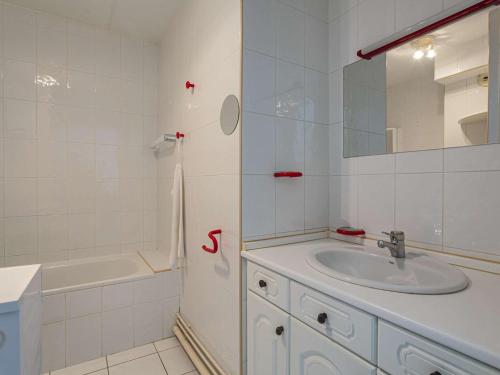une salle de bain avec un lavabo, une baignoire et un miroir dans l'établissement Appartement à 200 m de la plage avec terrasse et parking, au cœur des commerces et restaurants - FR-1-2-426, à Hendaye