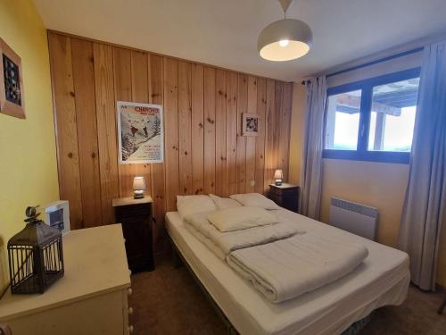 um quarto com uma cama grande e uma parede de madeira em Chalet Saint-Michel-de-Chaillol, 5 pièces, 9 personnes - FR-1-393-168 em Saint-Michel-de-Chaillol