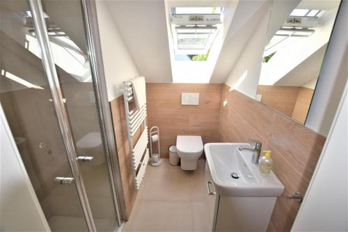 a small bathroom with a toilet and a sink at Wellenreiter-App-8-H in Hohwacht