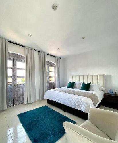a bedroom with a large bed and a blue rug at Suite Los Angeles in Tecozautla
