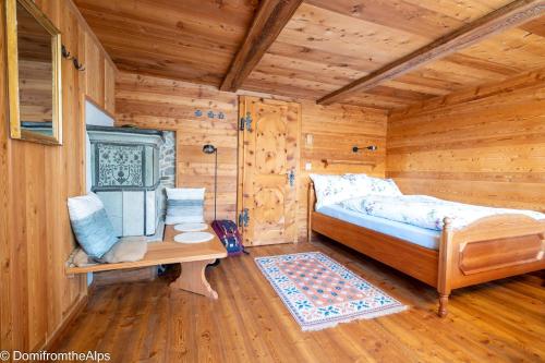 a bedroom of a log cabin with a bed and a table at Haus Zer Trächu in Saas-Almagell