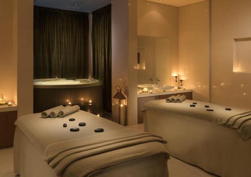 a bathroom with two beds with a sink and a mirror at Rixos The Palm Hotel & Suites - Ultra All Inclusive in Dubai