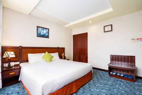 a hotel room with a large bed and a desk at LUCASTA SAIGON Hotel in Ho Chi Minh City