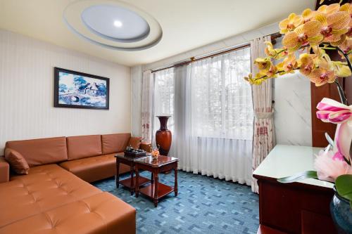 a living room with a couch and a table at LUCASTA SAIGON Hotel in Ho Chi Minh City