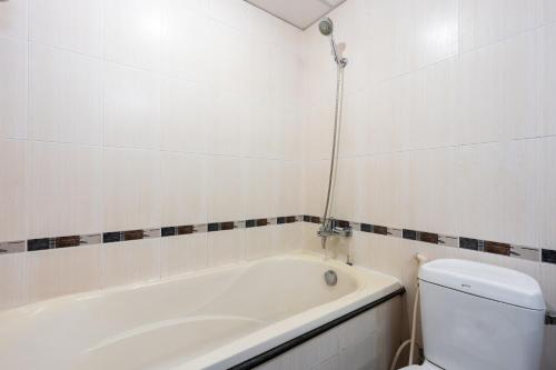a bathroom with a bath tub and a toilet at LUCASTA SAIGON Hotel in Ho Chi Minh City