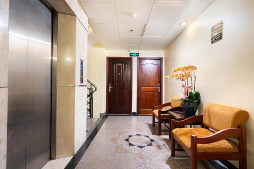 a corridor of a hospital with chairs and a door at LUCASTA SAIGON Hotel in Ho Chi Minh City