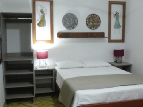 1 dormitorio con 1 cama y 2 platos en la pared en Casa Montero, acogedora y amplia. Iquitos-Peru, en Iquitos
