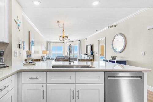 a kitchen with a sink and a living room at Emerald Isle Unit 703 in Pensacola Beach