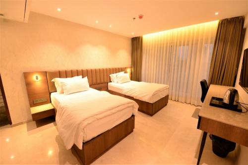 a hotel room with two beds and a television at HOTEL ANUPAM RESIDENCY in Mumbai