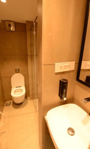 a bathroom with a toilet and a sink at HOTEL ANUPAM RESIDENCY in Mumbai