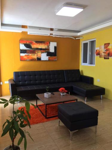 a living room with a black couch and a coffee table at 5 Min Walk To Famous Blue Water Resort And Tourist Area in Maribago