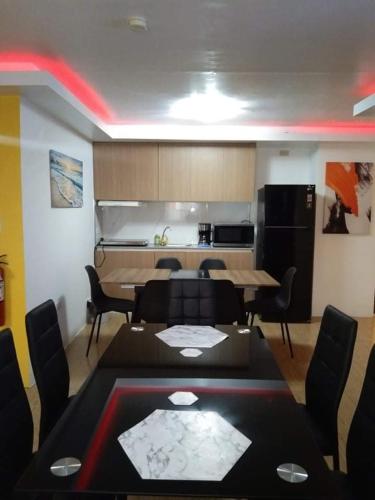 a living room with a table and chairs and a kitchen at 5 Min Walk To Famous Blue Water Resort And Tourist Area in Maribago