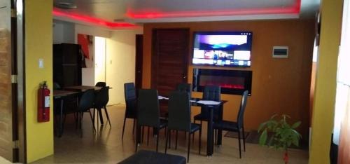 a dining room with a bar with chairs and a television at 5 Min Walk To Famous Blue Water Resort And Tourist Area in Maribago
