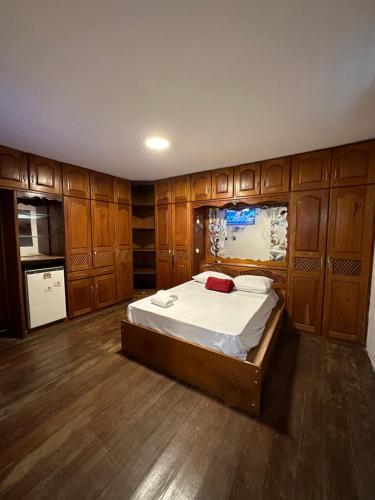 - une chambre avec un grand lit et des placards en bois dans l'établissement Casa de Hospedagem Ferreira - São Francisco, à São Luís