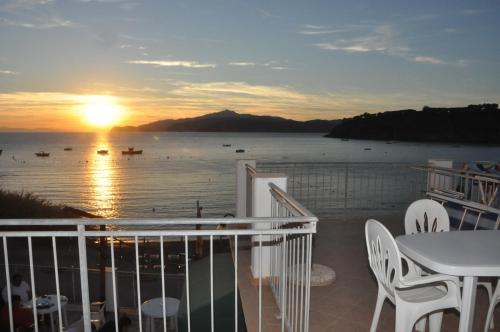 a balcony with a view of the ocean at sunset at Appartamenti Villa Miramare in Capoliveri
