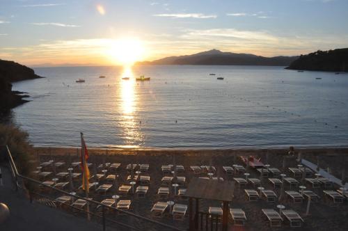 a view of a large body of water with chairs at Appartamenti Villa Miramare in Capoliveri