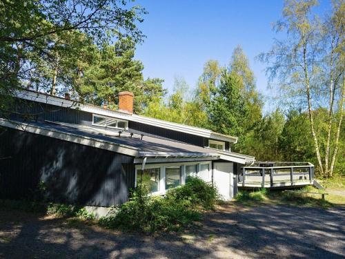 een wit huis met een veranda en een hek bij 14 person holiday home in Nex in Snogebæk
