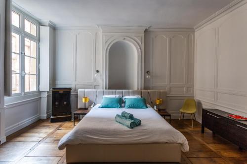 sypialnia z dużym łóżkiem i niebieskimi poduszkami w obiekcie Appartement design au coeur de Rennes w mieście Rennes