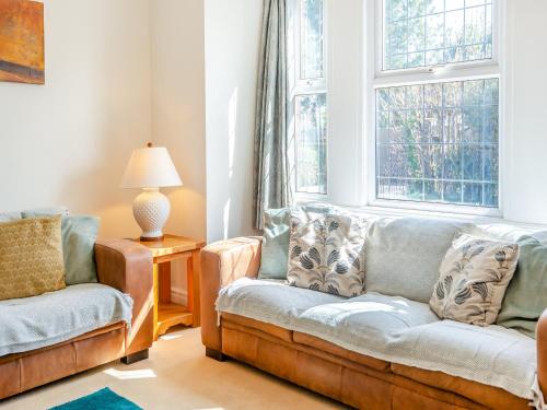 a living room with two chairs and a couch and a window at Hill House in Sholden