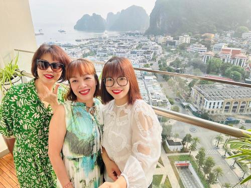 three women posing for a picture on top of a building at Mon Sapphire Homestay * View Sea and Poem Mountain in Ha Long