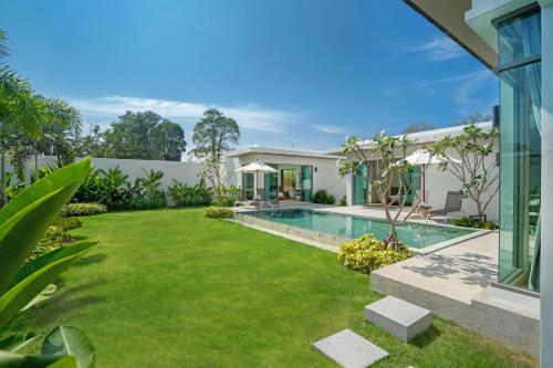 an image of a backyard with a swimming pool and grass at Shambhala Grand Villa - Private Pool Villas by Escape Villas - Top Choice - Guest Favorite - Best Location in Bang Tao Beach