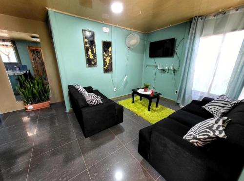 a living room with two couches and a tv at Casa Mar y Arena in Golfito