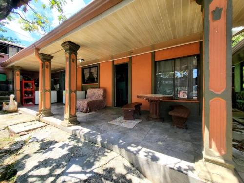 a porch of a house with a table and chairs at Casa Mar y Arena in Golfito