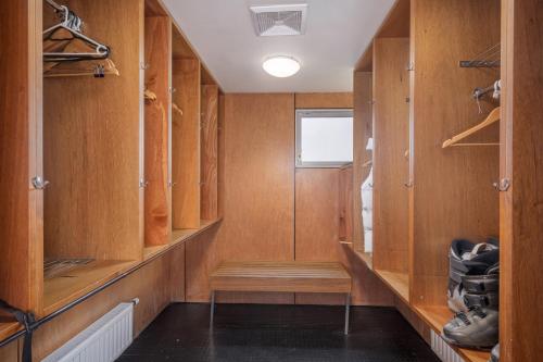 a walk in closet with wooden cabinets and shoes at Kooloora Lodge in Perisher Valley