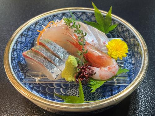 a blue plate of food with sushi on a table at 割烹旅館霞ヶ浦 in Itako