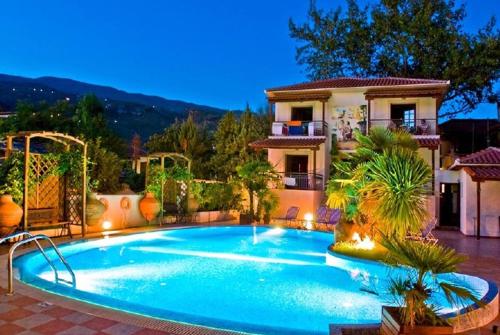 a swimming pool in front of a house at Enalion Hotel in Kala Nera